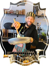 a man in an apron is cooking food in a kitchen